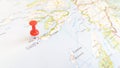 A red pin stuck in the island of Iona on a map of Scotland