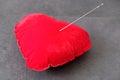 Red pincushion and a large sewing needle, needle spell Royalty Free Stock Photo
