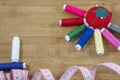 Red pincushion and several colourful threads as a sun and two treads as a boat