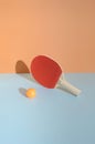 A red ping pong racket on a blue background with a ball in front. Sport table tennis still life concept Royalty Free Stock Photo