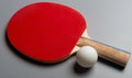 Red pingpong racket & ball on a grey background