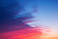 Red, pink and blue bright sunset with beautiful diagonal clouds.