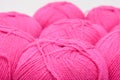 Red pink colorful skeins of yarn close up, fuchsia color woolen yarn for crochet and knitting, hobby and handmade concept Royalty Free Stock Photo