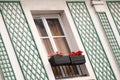 Red and pink flower window with white wall and green rhomboid decoration in montmartre