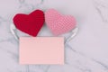 Red and pink hearts use headphone together with orange note on white marble background with copy space. Concept of couple, lover,