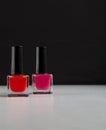 Red and pink nail polish bottles on balck and white background