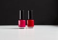 Red and pink nail polish bottles on balck and white background