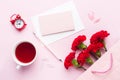 Red-pink objects. Cup of tea, carnation flowers Notepad for text on pastel pink background. Copy space. Top view Flat lay Royalty Free Stock Photo