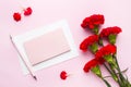 Red-pink objects. Cup of tea, carnation flowers Notepad for text on pastel pink background. Copy space. Top view Flat lay Royalty Free Stock Photo