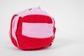 Red and pink soft textile washable snuffle toy in shape of cube for hiding delicious treats for dogs nose work, white