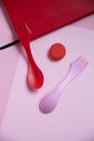 Red and pink still life with spoons, notebook and lids