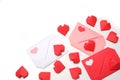 Red, pink and white paper envelopes with colored hearts, surrounded by several handmade red 3D paper hearts on white background