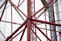 Red pipeline against the blue sky, bridge supports, metal structures. Royalty Free Stock Photo