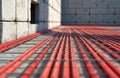 Red pipes for underfloor heating laid on concrete. Building construction site with modern climate control system installation. Royalty Free Stock Photo