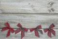 Red plaid Christmas bows border rustic wooden background