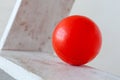 Red plastic ball on white ledders step background
