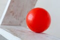 Red plastic ball on white ledders step background Royalty Free Stock Photo