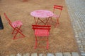 Red plastic benches in the shape of blocks with handles. The square is paved with granite cubes. sandy surface. built around a squ