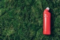 Red plastic bottle of cleaning product, household chemicals or liquid laundry detergent on green grass, moss background Royalty Free Stock Photo