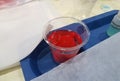 Red plastic capsule in solution for making bouncy balls