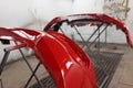 Red plastic car bumper drying after repainting in spraying booth Royalty Free Stock Photo