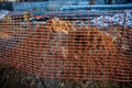 Red plastic caution fence with mesh during excavation or repair work in winter