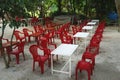 Colorful red and white plastic chairs and tables at an outdoor cafe in rural Vietnam