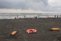Red plastic floatation rescue devices and sunbeds on beach. cloudy weather, overcast