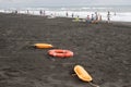 Red plastic floatation rescue devices and sunbeds on beach. overcast. Travel or sea vacations concept