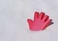 Red plastic hand toy on a white sand beach Royalty Free Stock Photo