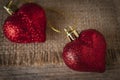 Red plastic hearts placed on sack and wooden table Royalty Free Stock Photo