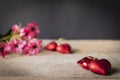 Red plastic hearts placed on a wooden table There is a flower placed on the left back There are red plastic hearts placed backside Royalty Free Stock Photo