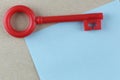 Red Plastic key is placed on Blue Paper Note. Royalty Free Stock Photo