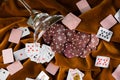 Red plastic poker chips fell out of a glass margarita glass onto a brown velvet fabric Royalty Free Stock Photo