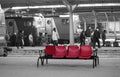 Red plastic seats on busy railway station platform