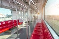 Red plastic seats and chrome handrails inside an electric train carriage car Royalty Free Stock Photo