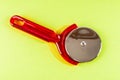 A red plastic spatula with a silver pizza cutter on top Royalty Free Stock Photo