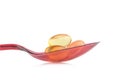 red plastic spoon.Capsules fish oil isolate on white background