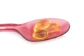 red plastic spoon.Capsules fish oil isolate on white background