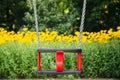 Red plastic swing hanging from chains in a children's park. Royalty Free Stock Photo