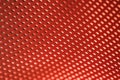 Red plastic texture with rectangular holes in the blur