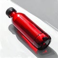 Red Plastic Water Bottle on White Surface with Direct Sunlight Royalty Free Stock Photo