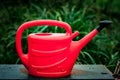 Red plastic watering can