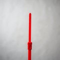 A red plastic zip tie is vertically positioned against a plain gray background. It features Royalty Free Stock Photo