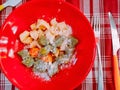 Red plate containing gnocchi of various colors