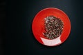 Red plate with a mixture pepper on a dark background