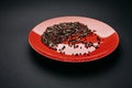 Red plate with a mixture pepper on a dark background