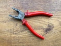 Red pliers isolated on wooden background close-up top view. Hardware store. Repairing Royalty Free Stock Photo