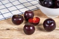 Red plums on wooden background