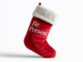 A red plush Christmas stocking with a white fluffy cuff and embroidered text Be Present Royalty Free Stock Photo